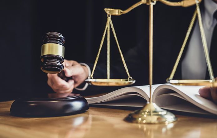 Male lawyer or judge working with contract papers, Law books and