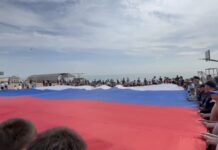 На городском пляже Махачкалы развернули триколор в рамках акции «Зарядка с чемпионом»