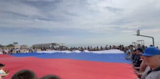 На городском пляже Махачкалы развернули триколор в рамках акции «Зарядка с чемпионом»